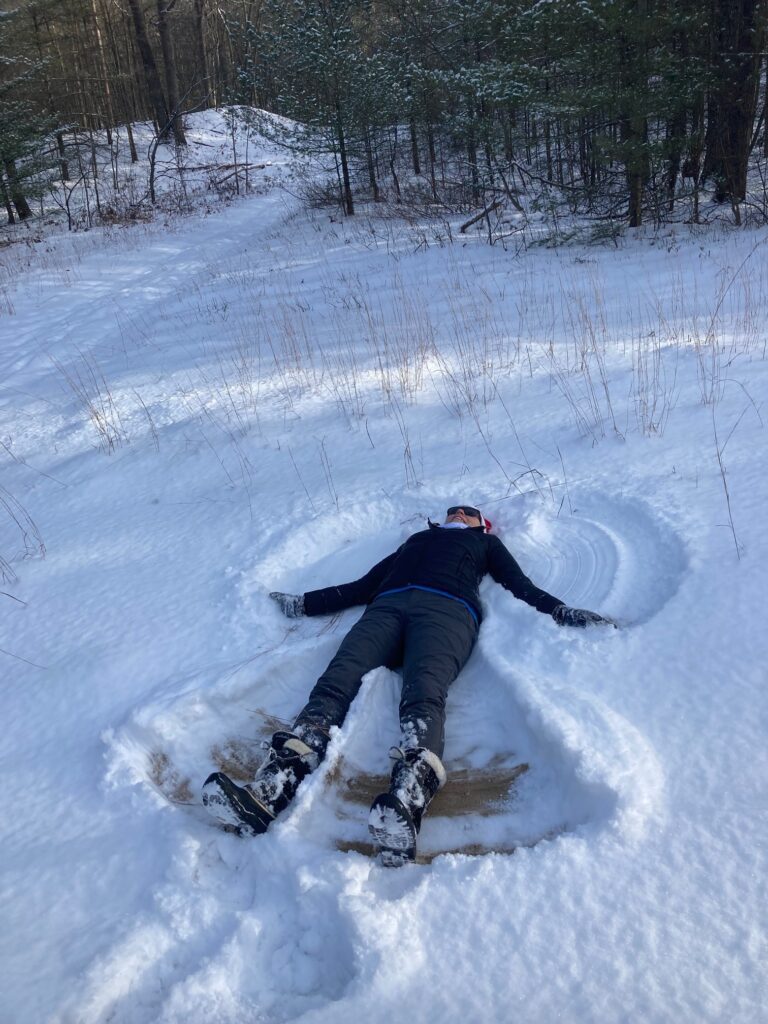 Snow angel Person wearing snowshoes making a snow angel