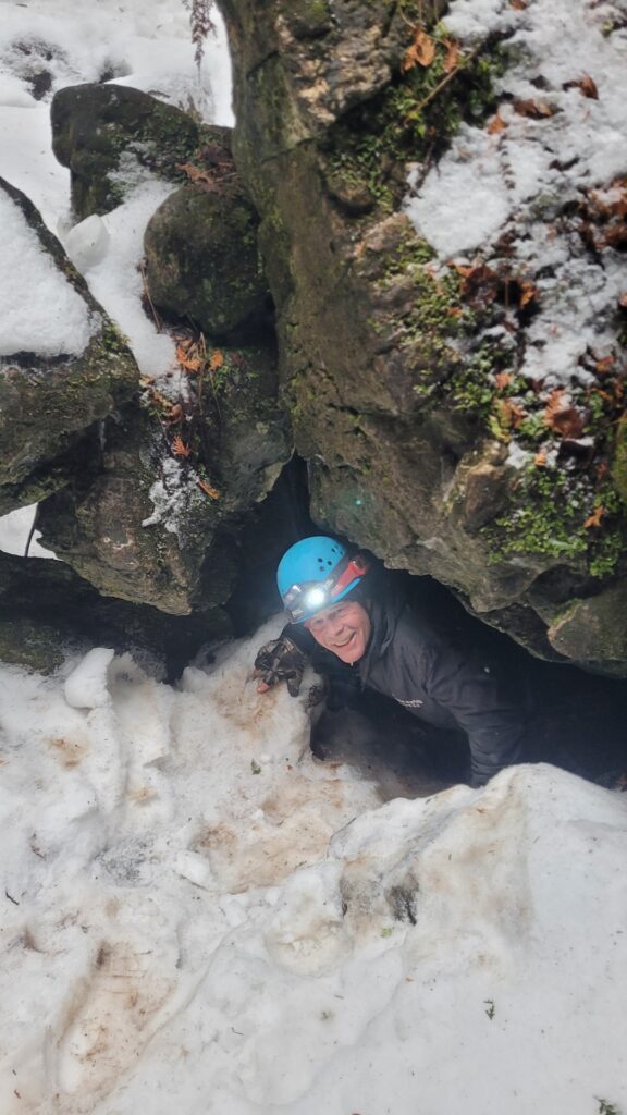 Winter caving Tour guide exiting a cave