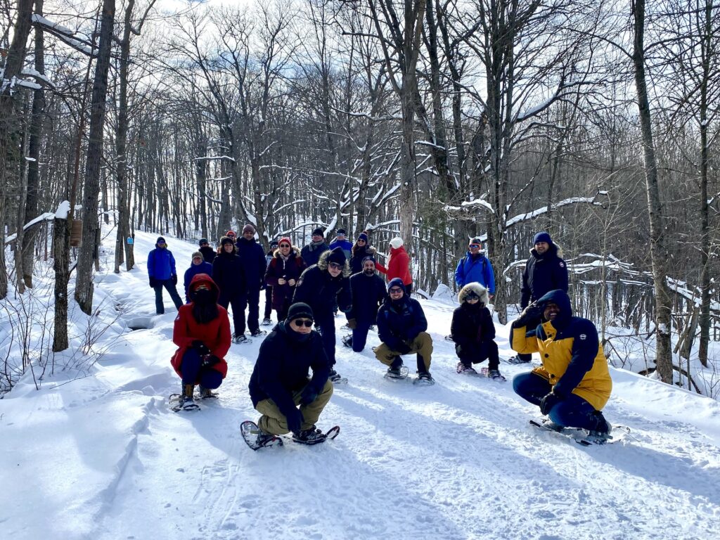Shoe and brew Group of snowshoers squatting
