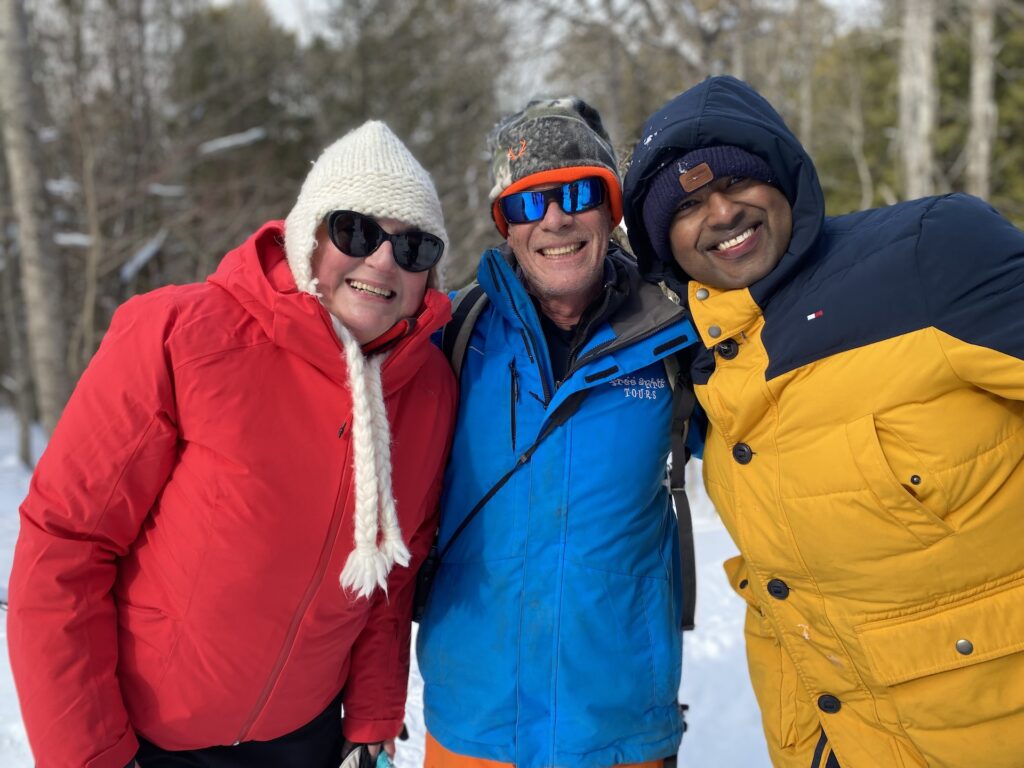 Shoe and Brew Three people smiling in snowy woods